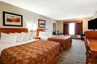 a hotel room with two beds and a television at Canalta Rocky Mountain House in Rocky Mountain House
