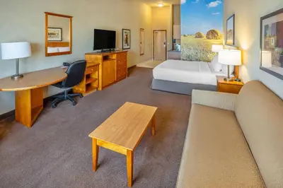 a hotel room with a bed and a desk at Clarion Pointe in Rimbey