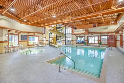 a large indoor pool with a slide in a building at Clarion Pointe in Rimbey