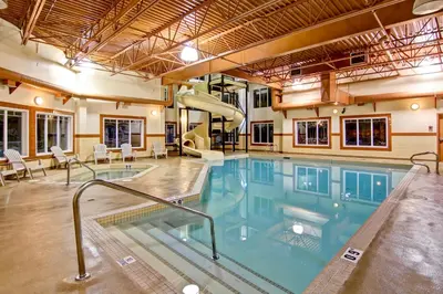 a swimming pool with a slide in a building at Ramada by Wyndham Ponoka in Ponoka