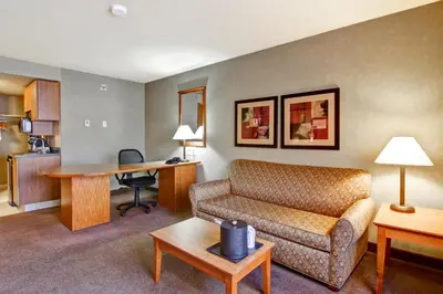 a living room with a couch and a table at Ramada by Wyndham Ponoka in Ponoka