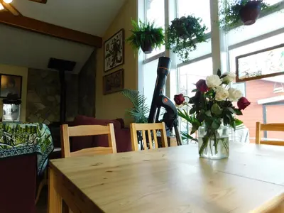a dining room table with a vase of flowers on it at The Calgary Hub hostel style Home in Calgary
