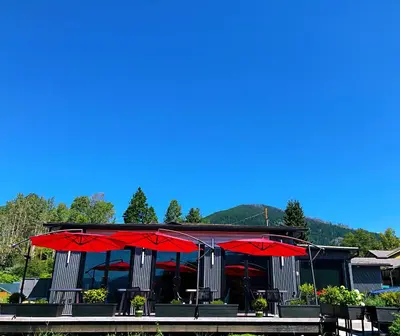 a restaurant with red umbrellas in front of it at Kokanee Glacier Resort in Nelson