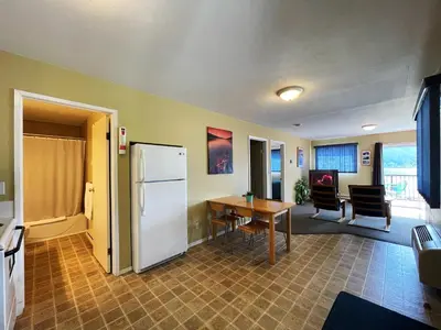 a kitchen with a table and a refrigerator in a room at Kokanee Glacier Resort in Nelson