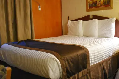 a bedroom with a large bed with white pillows at Hope Inn and Suites in Hope