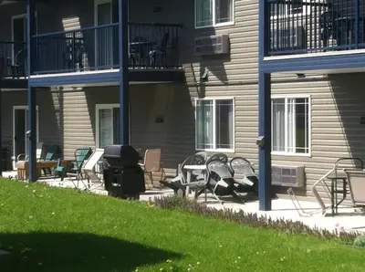 a group of chairs and tables on a patio in front of a building at New Horizon Motel in Christina Lake