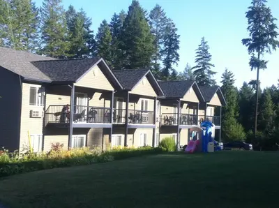 a large house with a playground in front of it at New Horizon Motel in Christina Lake