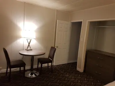 a room with a table and two chairs and a lamp at Holiday Motel & RV Resort in Hope