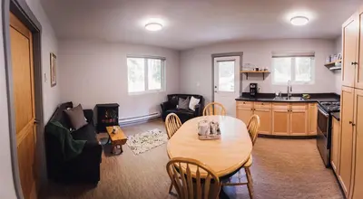 a living room with a table and a kitchen at Across the Creek Cabins in Clearwater