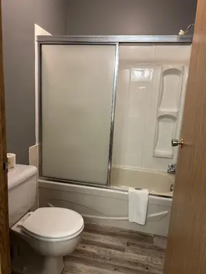 a bathroom with a toilet and a glass shower at Rimbey Motor Inn in Rimbey