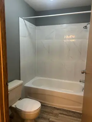 a bathroom with a toilet and a tub and a sink at Rimbey Motor Inn in Rimbey