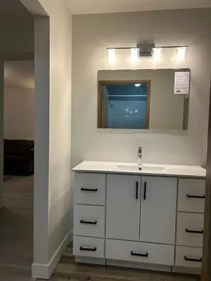 a bathroom with a white sink and a mirror at Rimbey Motor Inn in Rimbey