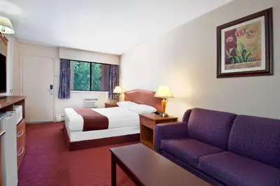 a hotel room with a bed and a couch at Deer Park Inn in Red Deer