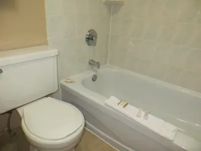 a bathroom with a toilet and a bath tub with at Deer Park Inn in Red Deer