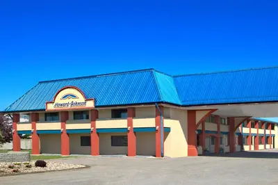 a large motel building with a blue roof at Deer Park Inn in Red Deer