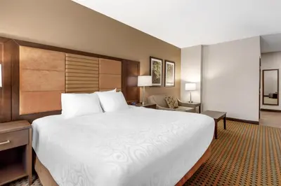 a hotel room with a large bed and a chair at Best Western Plus Hinton Inn & Suites in Hinton