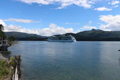 a cruise ship is docked on a river at Nimpkish Hotel in Alert Bay