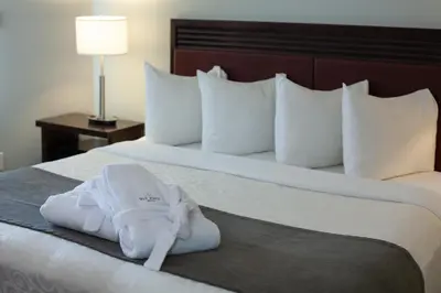 a hotel room with a towel on a bed at Old House Hotel in Courtenay