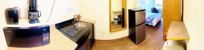 a room with a refrigerator with a phone on a counter at Grande Mountain Lodge in Grande Cache