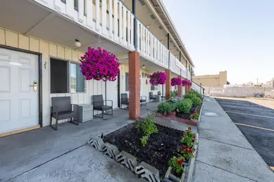 a building with flowers and plants on a sidewalk at 5000 Motel in Penticton