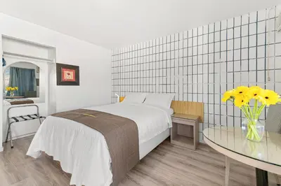 a bedroom with a bed and a table with yellow flowers at 5000 Motel in Penticton