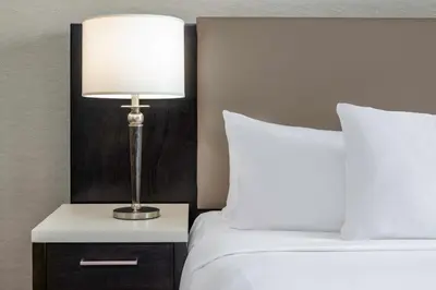 a lamp on a night stand next to two beds at Hilton Vancouver Metrotown in Burnaby