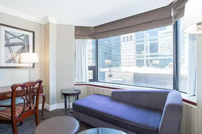 a living room with a couch and a large window at Sandman Signature Edmonton Downtown Hotel in Edmonton
