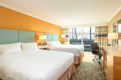 a hotel room with two beds and a desk at Hampton Inn & Suites, by Hilton - Vancouver Downtown in Vancouver