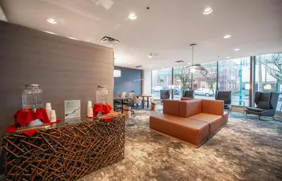 a lobby with a couch and a table and chairs at Coast Bastion Hotel in Nanaimo