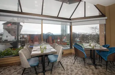 a dining room with tables and chairs and a large window at Coast Bastion Hotel in Nanaimo