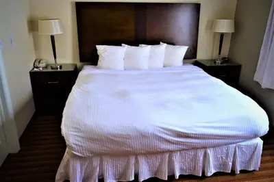 a large white bed in a hotel room at Sigma Inn & Suites Hudson's Hope in Hudson Hope