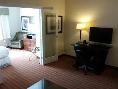 a hotel room with a bed and a desk and a television at Sigma Inn & Suites Hudson's Hope in Hudson Hope