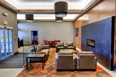 a lobby with couches and chairs and a fireplace at Radisson Hotel & Suites Fort McMurray in Fort McMurray