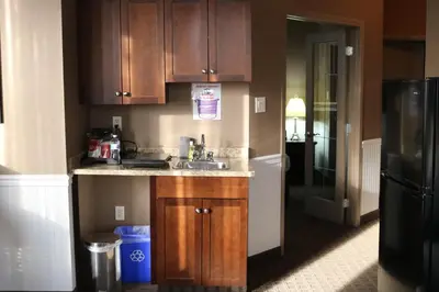 a kitchen with a sink and a refrigerator at Nomad Hotel & Suites in Fort McMurray