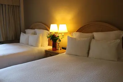 a hotel room with two beds with white pillows at Nomad Hotel & Suites in Fort McMurray