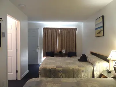 a hotel room with two beds and a window at 100 Mile Motel & RV Park in One Hundred Mile House