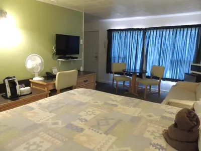 a room with a bed and a living room at 100 Mile Motel & RV Park in One Hundred Mile House