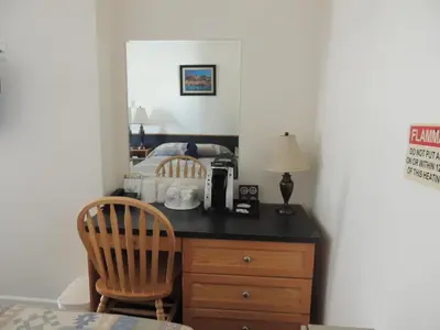 a bedroom with a desk with a coffee maker and two chairs at 100 Mile Motel & RV Park in One Hundred Mile House