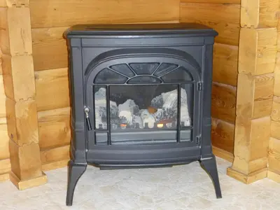 a black fireplace in a room with a wooden wall at Mica Mountain Lodge & Log Cabins in Tete Jaune Cache