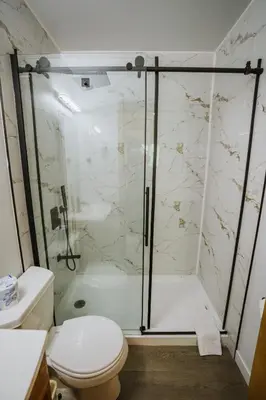 a bathroom with a shower and a toilet at Helmcken Falls Lodge Cabin Rooms and RV Park in Clearwater
