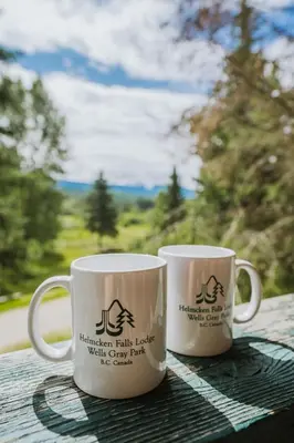two coffee mugs sitting on top of a table at Helmcken Falls Lodge Cabin Rooms and RV Park in Clearwater