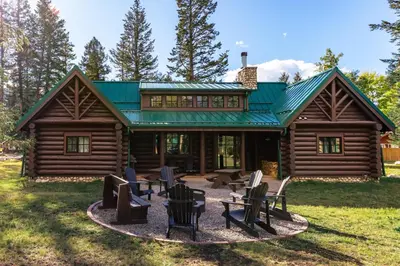 a log cabin with chairs in front of it at Pine Bungalows in Jasper