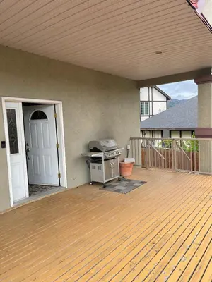 a patio with a bbq grill on a deck at Apple Tree Inn in Penticton