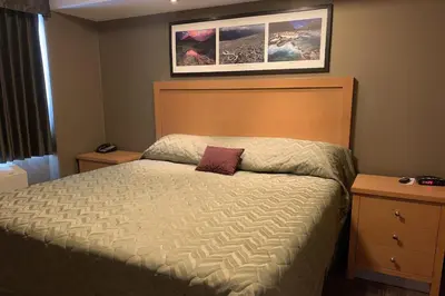 a bedroom with a bed and two night stands at Woodlands Inn & Suites in Fort Nelson