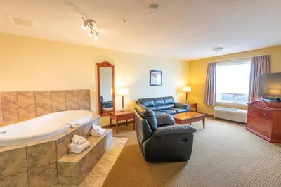 a living room with a large tub and a couch at Days Inn by Wyndham Bonnyville in Bonnyville