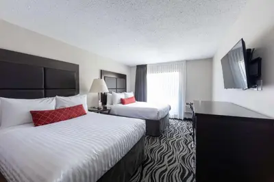 a hotel room with two beds and a flat screen tv at SureStay Hotel by Best Western Castlegar in Castlegar