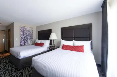 a hotel room with two beds with red pillows at SureStay Hotel by Best Western Castlegar in Castlegar