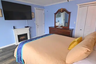 a bedroom with a bed and a tv on the wall at The Oceanfront Inn on Stephens Bay in Coal Harbour