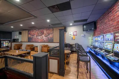 a restaurant with tables and chairs and a bowling alley at Coast Nisku Inn & Conference Centre in Nisku
