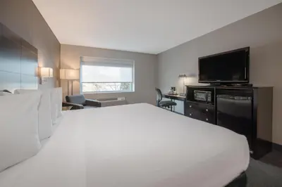 a hotel room with a bed and a flat screen tv at Coast Nisku Inn & Conference Centre in Nisku
